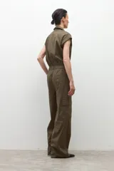 Mono de estilo utilitario color verde oliva, con cuello camisero, cierre frontal con botones, mangas cortas y bolsillos tipo cargo.