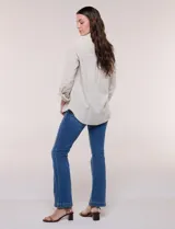 Camisa de lino marca Dash, color beige, con cuello con solapa, escote en V y cierre frontal con botones. Presenta mangas largas regulables con presilla y botón, y un bolsillo aplicado en el pecho.