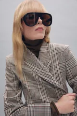 Blazer de cuello solapa y manga larga con diseño de cuadros. Presenta cierre frontal cruzado con botones.