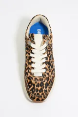 Zapatillas deportivas con estampado animal print, confeccionadas con piezas de piel con pelo. Lengüeta con etiqueta logotipada y parte trasera de piel con adorno metálico logotipado. Nuevo piso con estabilizador personalizado, entresuela de eva y suela bicolor con acabado dentado y logo.