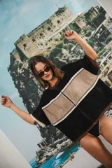 Remera de punto con diseño retro de bloques de color en marrón, crema y celeste. Presenta cierre frontal, cuello redondo, mangas cortas y tejido calado en la parte inferior. Incluye detalle de logo en relieve en el frente.