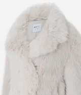 Saco corto de pelo artificial en color beige, con cuello amplio, mangas largas y diseño holgado. Cuenta con forro interior de poliéster.