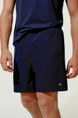 Bermuda deportiva gris con cintura elástica, bolsillos laterales y pequeño logo reflectante en el borde inferior.