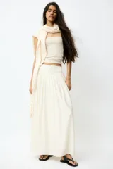 Pollera maxi de corte holgado en mezcla de viscosa, color beige. Cuenta con cintura en punto pesado con detalle fruncido en V que otorga una caída suave y fluida.