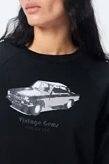 Remera negra cropped de manga corta con mangas ranglan, y estampado frontal de un auto antiguo con el texto "Vintage Gems".