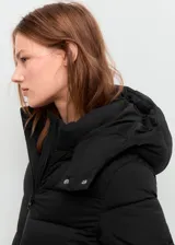 Campera acolchada tipo puffer de corte midi, color negro, con capucha, cierre frontal de cremallera doble, bolsillos laterales y puños elásticos.