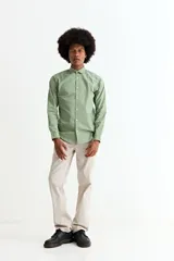 Camisa de manga larga en color beige, confeccionada en algodón, con cuello clásico y cierre frontal de botones.