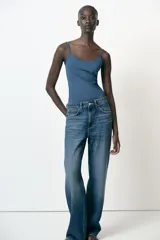 Camiseta ajustada negra con escote redondo y tirantes finos.