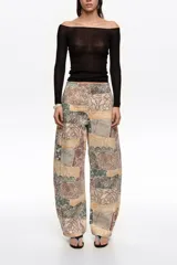 Pantalón balloon de tiro medio confeccionado en algodón, con diseño estampado tipo patchwork en tonos beige, marrón y verde, corte abotinado y bolsillos laterales.