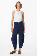 Jean de corte balloon en color azul marino, con cintura alta, cierre frontal con botón y bolsillos laterales. Presenta costuras laterales curvadas que definen su silueta amplia y relajada.