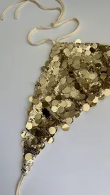 Top dorado con lentejuelas, estilo halter, con tiras regulables en cuello y espalda.