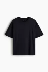 Remera de punto de algodón de peso medio en color negro, con cuello redondo ribeteado, hombros caídos, mangas cortas y corte relajado.
