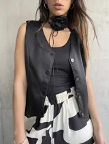 Chaleco sastrero negro con botones, de corte corto y moderno.