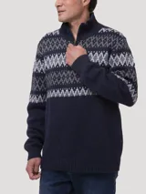 Sweater de punto con cierre frontal parcial y cuello alto. Presenta un diseño de patrón geométrico tipo jacquard en tonos grises y celestes sobre una base azul marino en la parte superior y mangas.