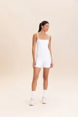 Jumpsuit corto de diseño ajustado con escote cuadrado y breteles finos. Confeccionado en tejido técnico con acabado ligeramente brillante y textura acanalada, ofrece compresión media y alta elasticidad.