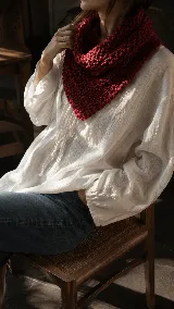 Bandana tejida artesanalmente en lana merino, con diseño triangular y textura de punto grueso. Es un accesorio versátil y térmico, ideal para usar como abrigo ligero en el cuello.