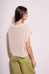 Chaleco sin mangas de tejido de punto color rosado pálido, con textura calada y acabado lurex, corte al cuerpo y cuello redondo.