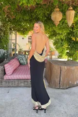 Vestido largo negro Lady Pipa con tirantes finos, escote en V y detalles en tejido dorado brillante en los laterales y el bajo.
