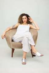 Sandalias de cuero color marrón con puntera abierta, talón descubierto y tira trasera con hebilla. Taco bajo de madera.