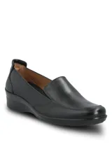 Zapato tipo slip-on de cuero liso color negro, con diseño de calce fácil, plantilla con relieves para ventilación y suela de caucho termoplástico con taco bajo.