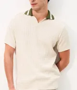 Remera polo de manga corta con textura retilínea, cuello polo en color verde contrastante y apertura frontal. Confeccionada en tejido de poliéster y algodón.
