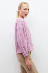 Blusa blanca de manga larga con escote en V y bordados en el frente.