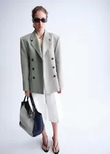 Blazer cruzado de lino y algodón color verde militar, con cuello solapa, hombreras marcadas, bolsillos con solapa y cierre de doble botonadura.