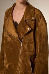Chaqueta tipo biker de gamuza sintética color tostado, con cuello solapa, cierre frontal y diseño holgado.
