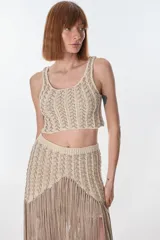 Top corto de tejido de punto en tonos beige y marrón claro, con diseño calado y escote redondo.