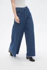 Pantalon de jean azul de corte ancho y tiro alto, con ruedo deshilachado.