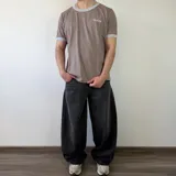 Pantalón jean de corte barrel, color azul clásico con efecto desgastado y diseño amplio y curvado en las piernas.
