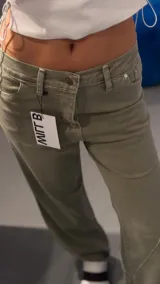 Pantalón de jean verde con corte recto y diseño de costuras diagonales en la parte delantera.