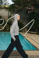 Sudadera de punto con hilo metalizado color gris, con capucha, manga larga y cierre frontal con cremallera.