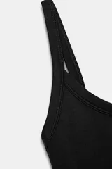 Body de cuello cuadrado con tirantes finos, confeccionado en tejido elástico con cierre inferior mediante botones a presión.