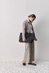 Pantalón de jean tiro medio con corte wide leg y estampado animal print. Presenta costuras verticales frontales y diseño de pierna amplia.