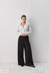 Pantalón wide leg de tiro medio y calce amplio, color marrón, con pinzas delanteras, cierre frontal y bolsillos laterales funcionales.