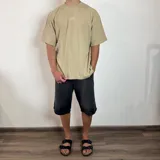 Remera de corte oversize color beige, con cuello redondo y estampa minimalista de un sol en el centro del pecho.