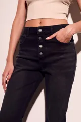 Pantalón de jean negro de corte flare con tiro medio y cierre frontal con botones.