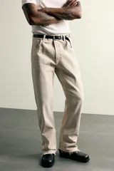 Jeans flare fit de tiro medio confeccionados en denim de algodón color beige, con cinco bolsillos, efecto salpicaduras y bajo irregular.