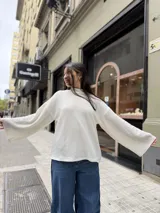 Polera de tejido de punto con textura tipo waffle, color crudo, de corte holgado y mangas anchas con puños acampanados.