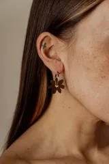Aros tipo argolla con dije colgante en forma de flor realizado en acrílico.