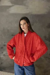 Campera acolchada de color azul marino, con diseño de rombos, cuello tipo chal y cierre frontal con botones grandes al tono. Presenta puños y ruedo acanalados, y bolsillos laterales.