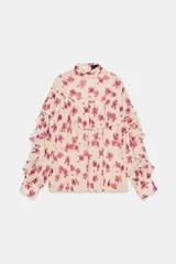 Blusa de cuello subido y manga larga con estampado floral en tonos rosados. Presenta un diseño con volantes en el pecho y a lo largo de las mangas, con cierre posterior mediante botones ocultos.