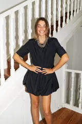 Vestido corto color verde oliva, de manga corta y corte holgado con frunce en la cintura que genera un efecto de falda globo (balloon).