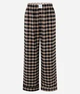 Pantalón de pijama de corte holgado confeccionado en franela con estampado de cuadros en tonos beige y negro. Presenta cintura elástica con botones decorativos en la parte frontal.