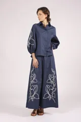 Pantalon de corte ancho y tiro alto, color azul marino, con bordados florales en color crema en la parte inferior de las piernas.