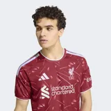 Camiseta de futbol Adidas del Liverpool FC, modelo primera equipacion inspirada en los anos ochenta. Diseno de color bordo con estampado geometrico en tonos claros, detalles blancos en el cuello y las bandas de los hombros, y los logos de la marca y el club en el pecho.