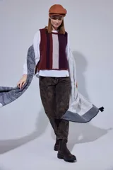 Chaleco de punto sin mangas con diseño de bloques de color en tonos bordó, marrón y beige, con detalle de trenzado central.