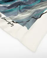 Maxi pañuelo de seda mulberry 100% firmado por Adolfo Domínguez, con diseño estampado de motivos de ajo en tonos gris, azul y turquesa sobre fondo blanco, y dobladillo hecho a mano.