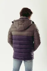 Campera puffer de abrigo con diseño bicolor, gris en la parte superior y violeta oscuro en la inferior. Cuenta con cierre frontal completo, capucha desmontable, bolsillos laterales con cierre y logo estampado en el pecho.